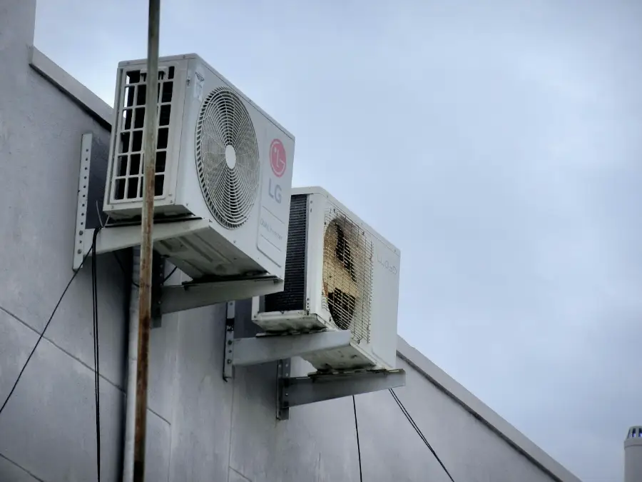 Two ageing outdoor units fixed to an external wall