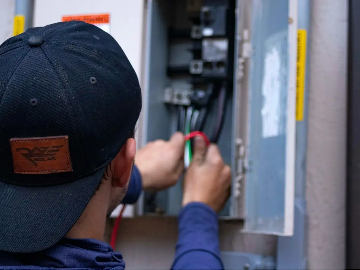 Engineer carrying out an air conditioning service on a wall-mounted indoor unit in a home