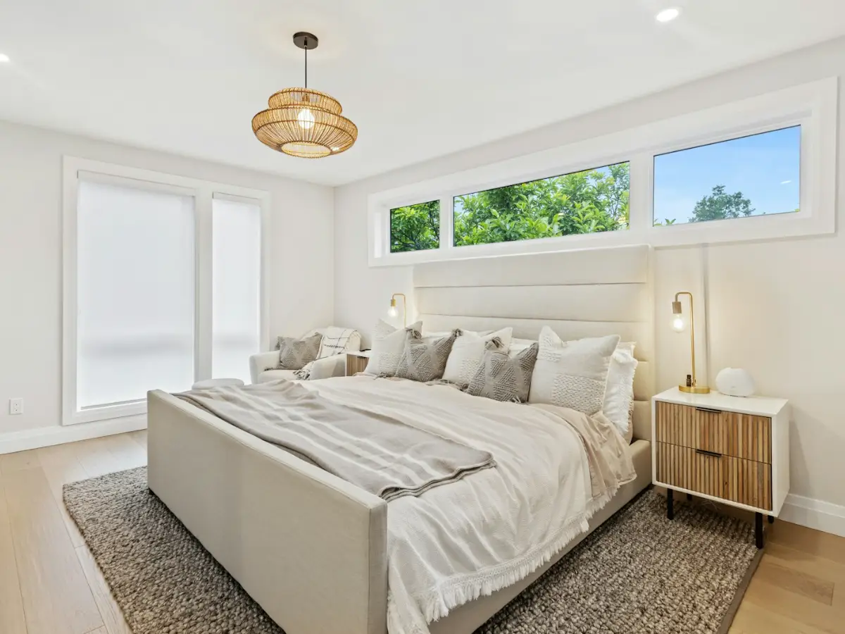 Bedroom air conditioning indoor unit fitted high on the wall of a bright bedroom