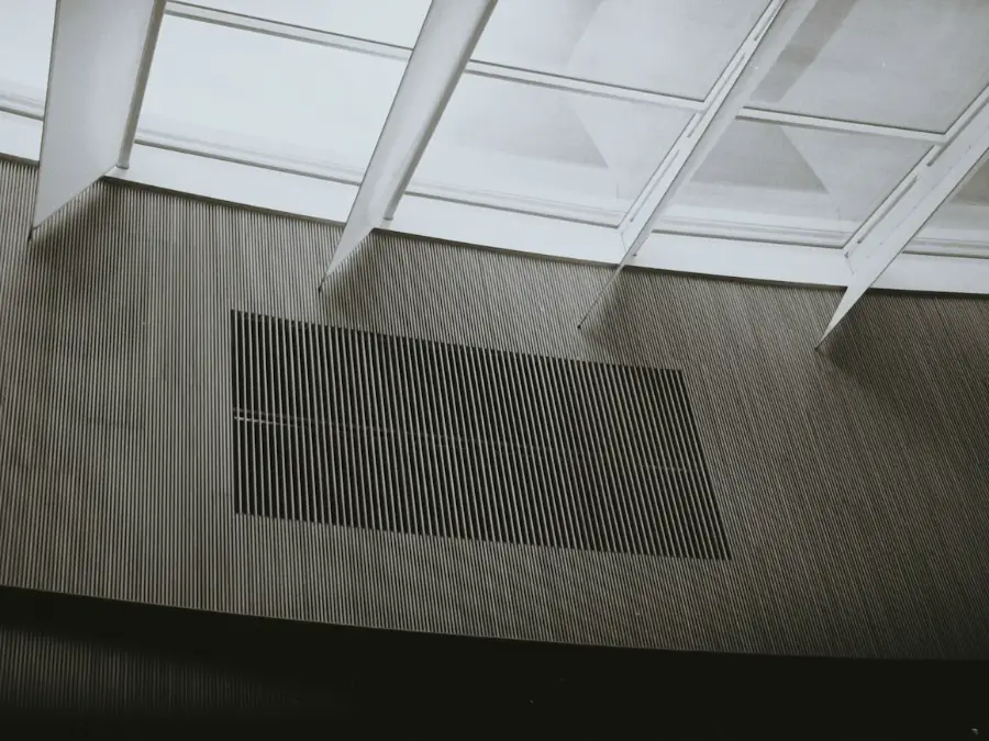 Slim linear supply grille set into a smooth plastered ceiling