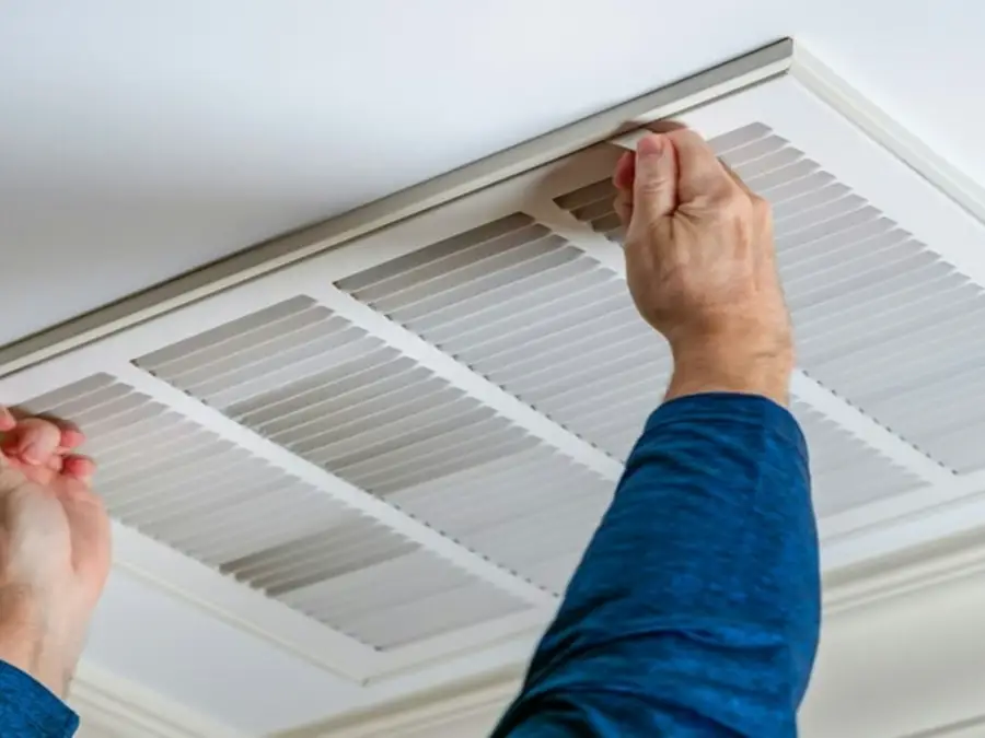 Ceiling return grille opened to show the filter behind it