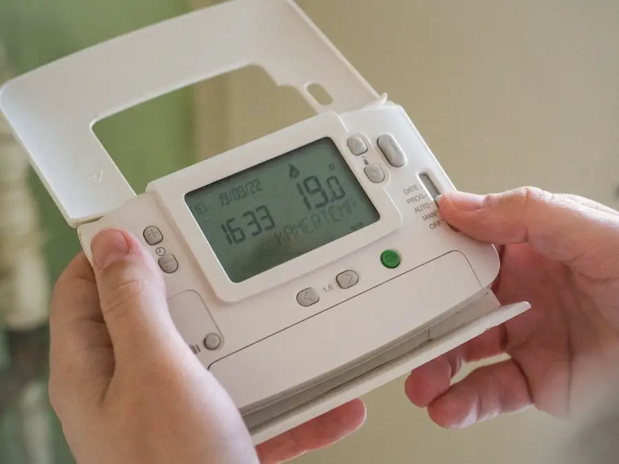 Hand holding a smart energy monitor showing live electricity use