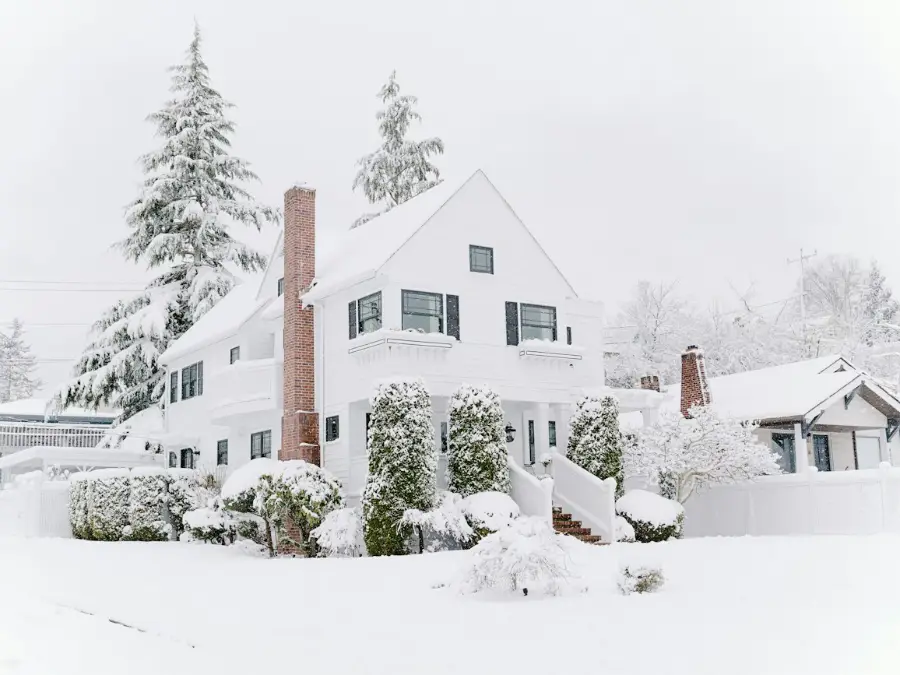 House in winter snow with an outdoor unit still running
