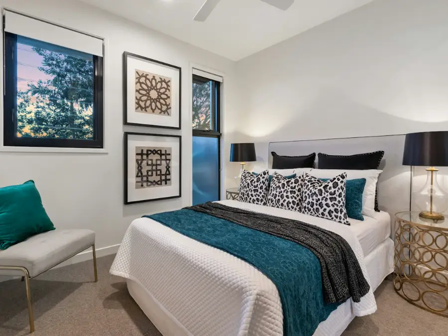 Hotel style bedroom with soft lighting and a made bed