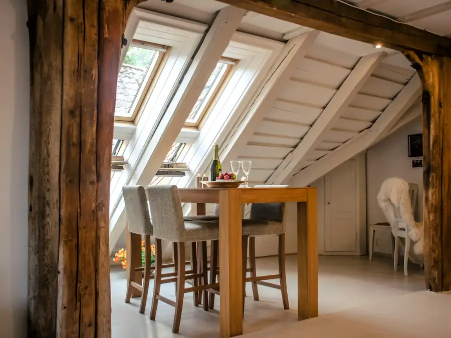 Loft dining area lit by skylights in a sloped ceiling