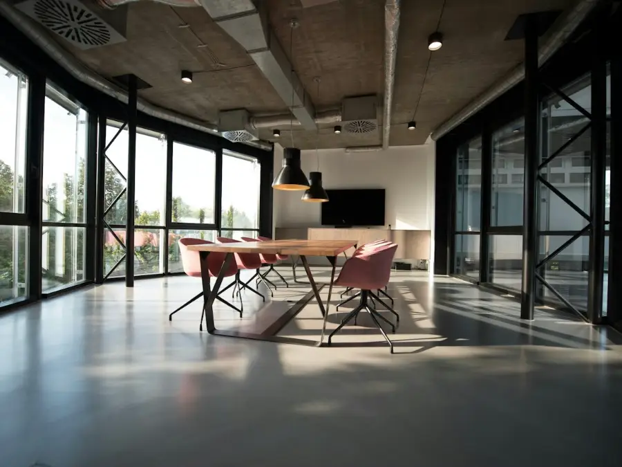 Office meeting space with a long table, chairs and large windows