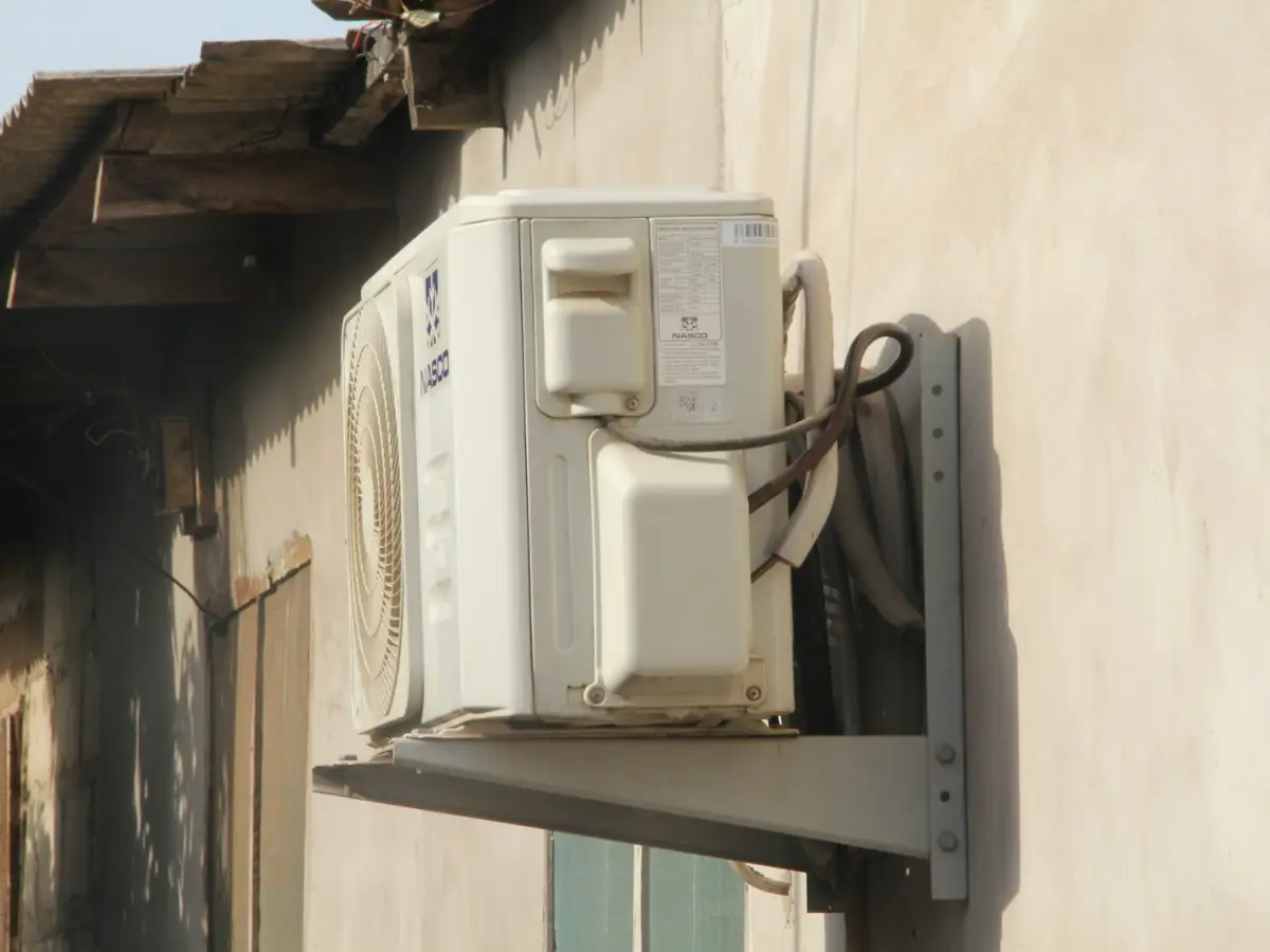 Old outdoor unit on a wall bracket, ready for replacing an AC unit with a new R32 system