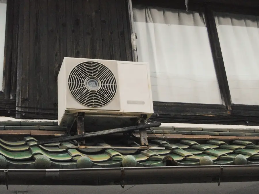 Outdoor unit fixed above a balcony rail