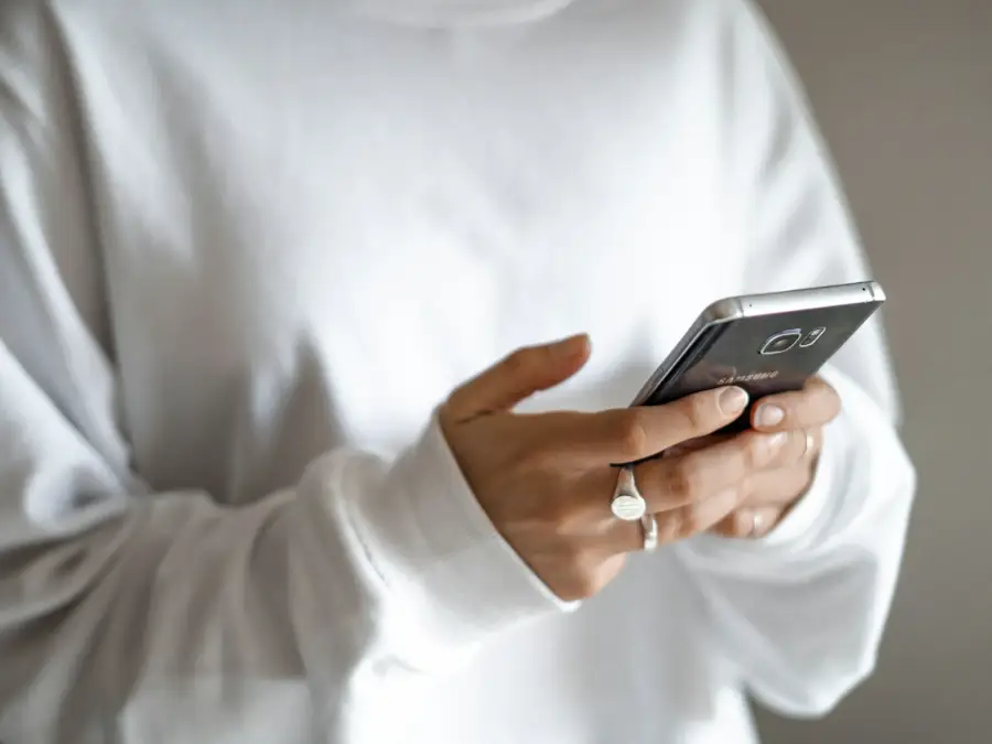Phone in hand typing a message with room photos attached