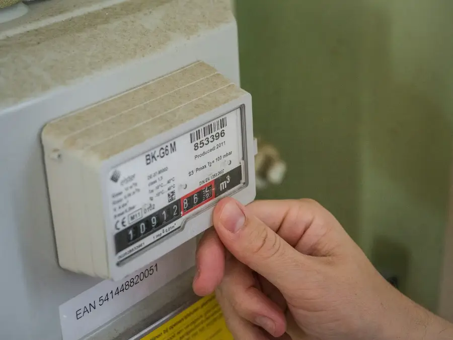 Person reading the display on a home electricity meter