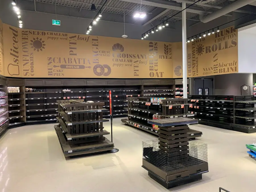 Retail shop interior with clothing rails, shelving and a long shop floor