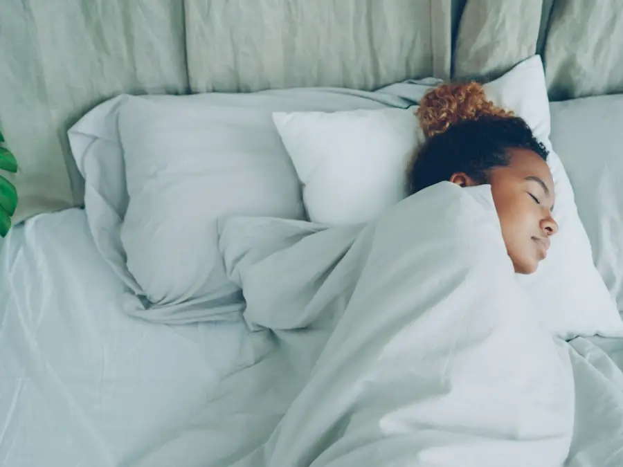 Person sleeping under white bedding in a bright room