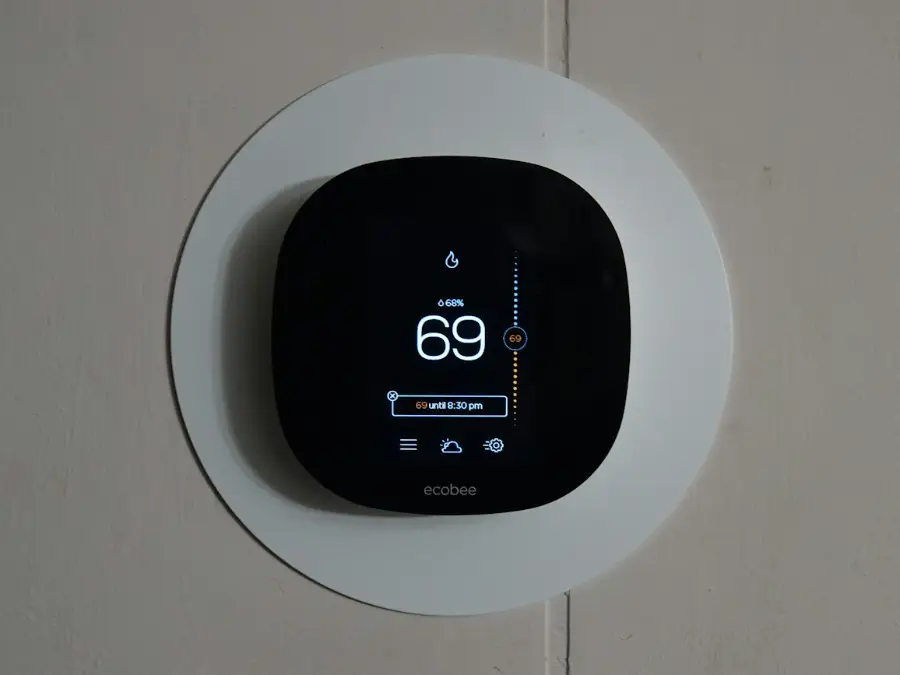 Smart thermostat on a wall showing room temperature